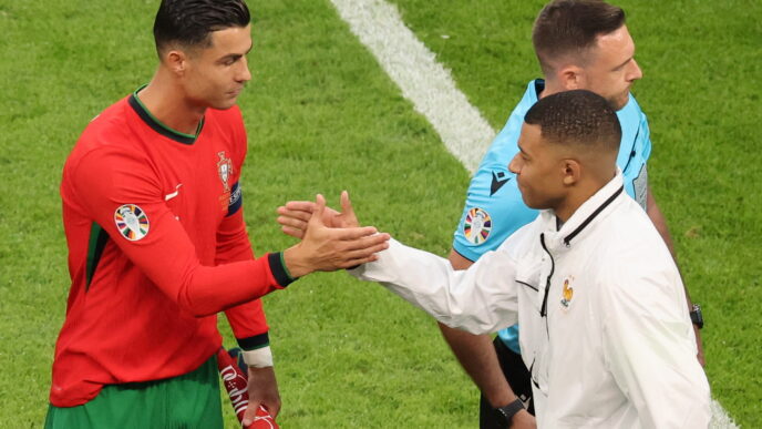 epa11460549 Cristiano Ronaldo of Portugal (L) shakes hands with Kylian Mbappe of France ahead of the UEFA EURO 2024 quarter-finals soccer match between France and Portugal, in Hamburg, Germany, 05 July 2024.  EPA/ABEDIN TAHERKENAREH